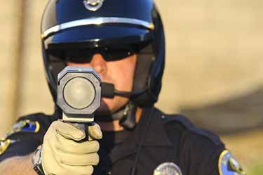 Police officer pointing radar gun