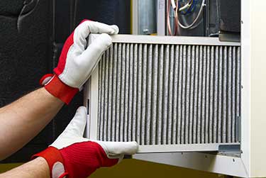 man replacing filter in a furnace