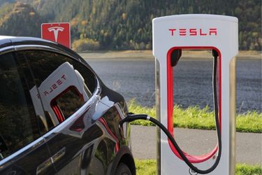 black car charging at tesla charging station