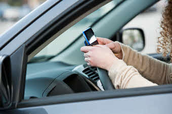Person with phone on steering wheel