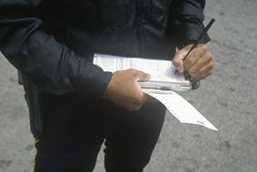 Traffic ticket being written by police officer 