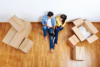 Couple sitting with coffee with moving boxes