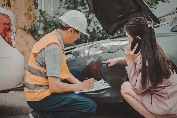 two people looking at a car for damage after an accident