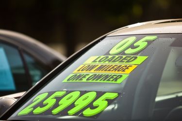 used car for sale with green text on window