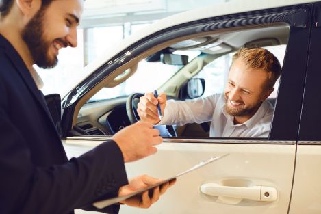 two men investing in a white car