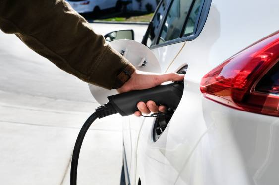 white hybrid charging, hand holding the charger