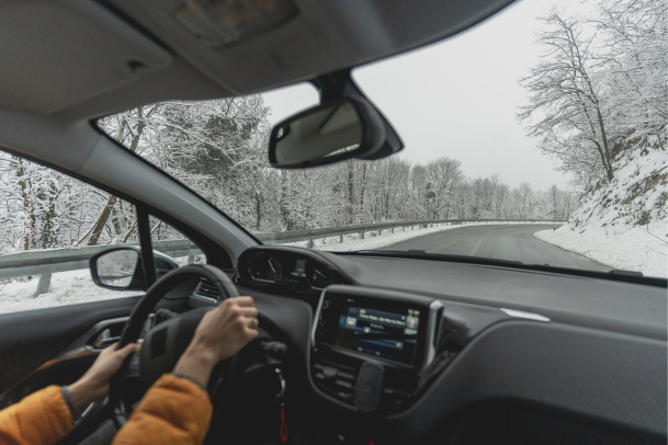 Person with yellow sweater driving winter road in Ontario