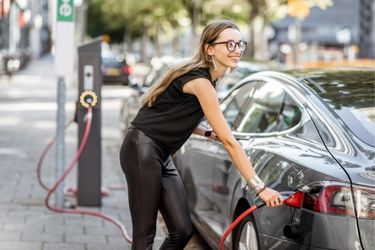 woman charging vehicle at EV station