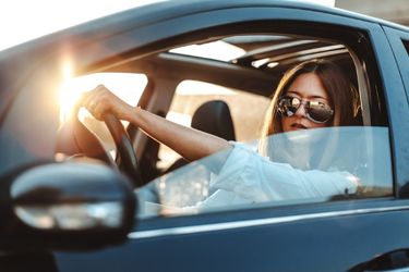 woman driving car at golden hour