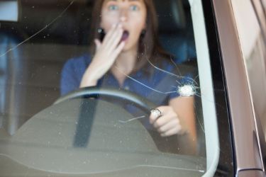 woman in car with cracked windowshield