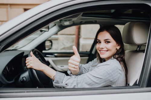 Female driver with thumbs up