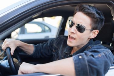 Young man with sunglasses in car stressed out